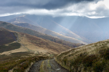 A path to the top of the mountain. The road to victory. Rays of light through the clouds.