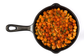 Fried spicy chickpeas in frying pan isolated on white background. Top view