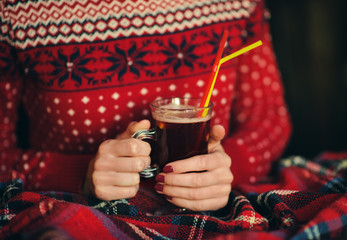 Cup with mulled wine in the hands of a girl