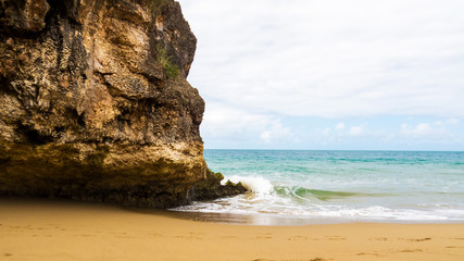 A rocky and sandy beach with a peaceful wave from the Atlantic Ocean. Sos&ugrave;a, Dominican Republic.
