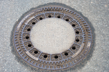 Round manhole cover on the footpath
