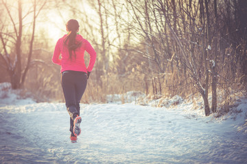 Photo from back of brunette athlete running in winter park