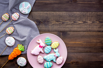 Easter bunny and easter eggs cookies. Sweets, pastry for Easter table. Dark wooden background top...