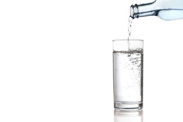 Naklejka na ściany i meble Wasser aus einer Flasche wird in ein Glas geschüttet