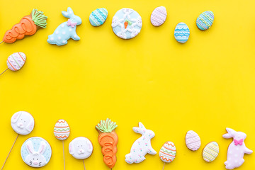 Easter gingerbread and cookies. Easter eggs and Easter bunny concept. Yellow background top view copy space
