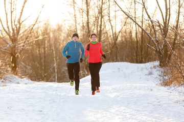 Image of running two athletes in winter park