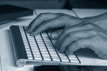 Hand on type desktop keyboard, working concept