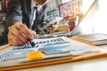  businessman hand working with laptop computer, tablet and smart phone in modern office with virtual icon diagram at modernoffice in morning light 