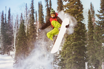 Snowboarder jumps at offpiste slope