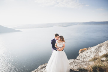 Fototapeta na wymiar Happy and romantic scene of just married young wedding couple posing on beautiful beach