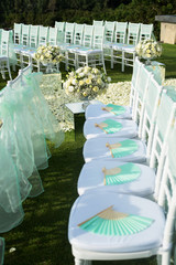 Beautiful wedding set up. Wedding ceremony on green lawn in the terrace. Part of the festive decor, floral arrangement.