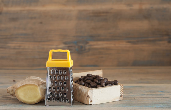 steel grater and ginger root on wooden table