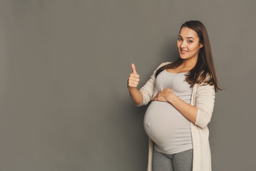 Pregnant woman with thumb up gesture