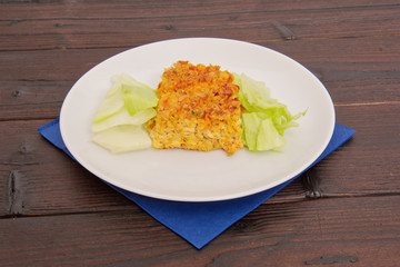 Baked rice with vegetables and salad on a table
