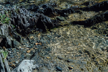 Stones, pebbles and sand on the shore of a mountain river