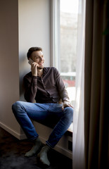 Young man with mobile phone in the room