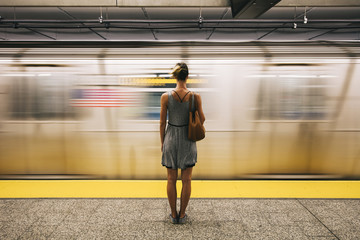 Young woman waiting for subway train in New York City - Powered by Adobe