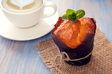 Chocolate muffins mint and coffee on wooden table