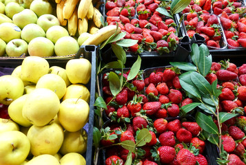 Fruit market. Apples and strawberries in boxes on the counter.