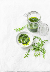 Arugula pesto on a light background, top view. Tasty seasoning for pasta, bruschetta