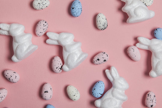 Pastel pink easter holiday background with eggs and easter bunnies