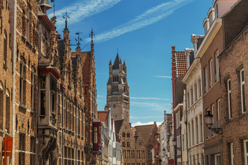 Tower of the Cathedral of Saint Salvator in Bruges, Belgium. Typical street with the medieval Flemish architecture and red brick houses.
