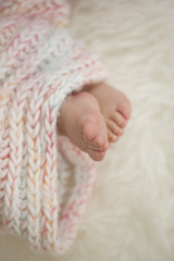 baby feet in blanket, copy space. selected focus