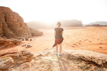 Person on a top of mountains in a desert. Sunset view. Nature. Tourist people enjoy a moment in a nature. Wadi rum national park - Jordan