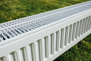 radiator on green lawn, ecological heating concept