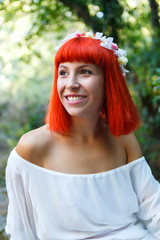 Beautiful woman with a flower wreath sitting near to a waterfall