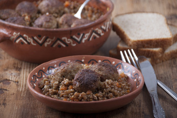 Meatballs with buckwheat porridge in a  clay dish