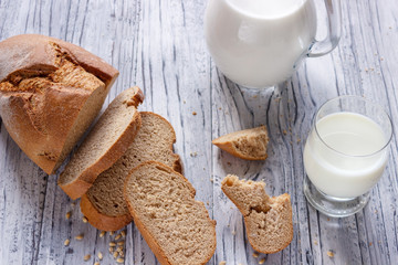 Still life with slices of bread and milk on a wooden background