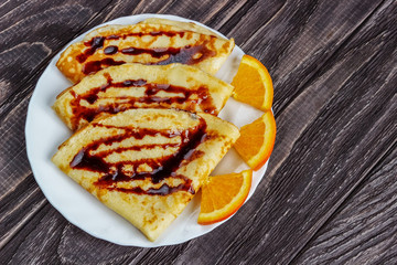 Pancakes on a white plate with honey and a cup of milk. Delicious breakfast.