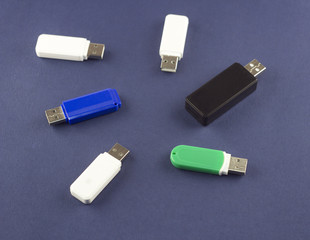 .Flash drives of different colors on a blue background
