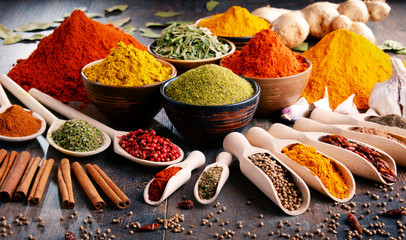 Variety of spices and herbs on kitchen table - obrazy, fototapety, plakaty
