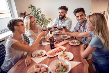 Young friends celebrate with alcohol and food