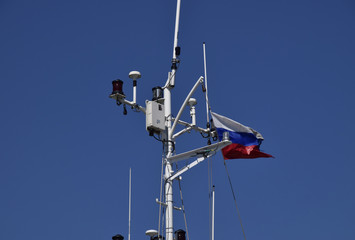 Mast of the port service ship. Devices of light signaling and communication antenna