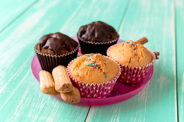 chocolate cupcakes with cookies on green wooden background.