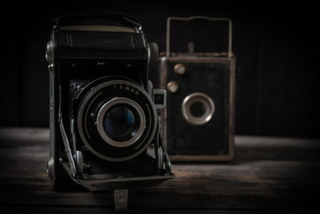 Stare aparaty fotograficzne stojące na starych surowych deskach - obrazy, fototapety, plakaty