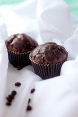 chocolate muffins with coffee beans on white fabric