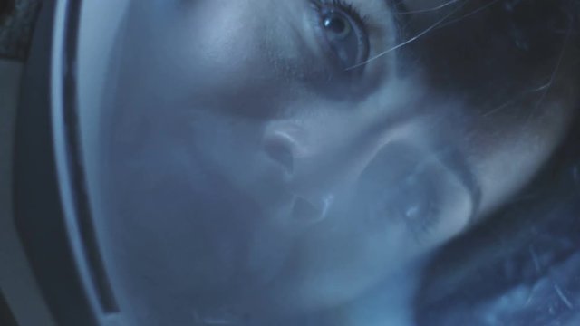 Spinning Portrait Shot of the Beautiful Female Astronaut Wearing Helmet in Space, Looking around in Wonder. Space Travel, Exploration. Shot on RED EPIC-W 8K Helium Cinema Camera.