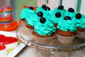 Tasty cupcakes on wooden background. Birthday cupcake in blue colors