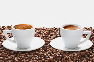 Two cups of hot coffee with coffee beans on white background