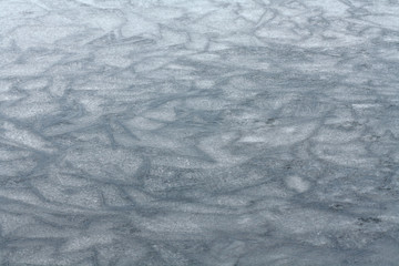 Thin Blue Ice Surface. Winter Day. Early Spring Melt. Warmer Winter Weather that Thaws Ice. Frozen River. The Ice Surface Melting. Unstable Surface of Defrosting Water.
