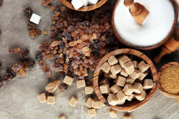Various types of sugar, brown sugar and white on table