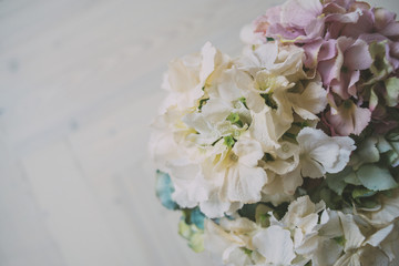 Fototapeta na wymiar colorful flowers in vase on the wooden floor macro