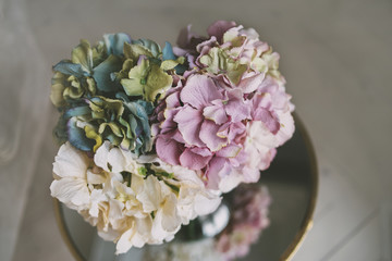 vase of colorful flowers on the mirror table with wooden floor