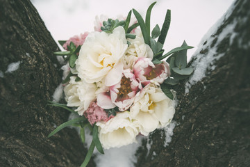 wedding bouquet between trees with snow horizontal