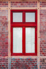 red window on brick facade