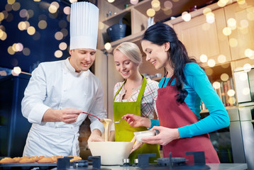 happy women and chef cook baking in kitchen